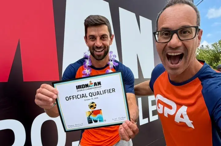 Dênis com o certificado de Official Qualifier do Mundial de Ironman ao lado do treinador